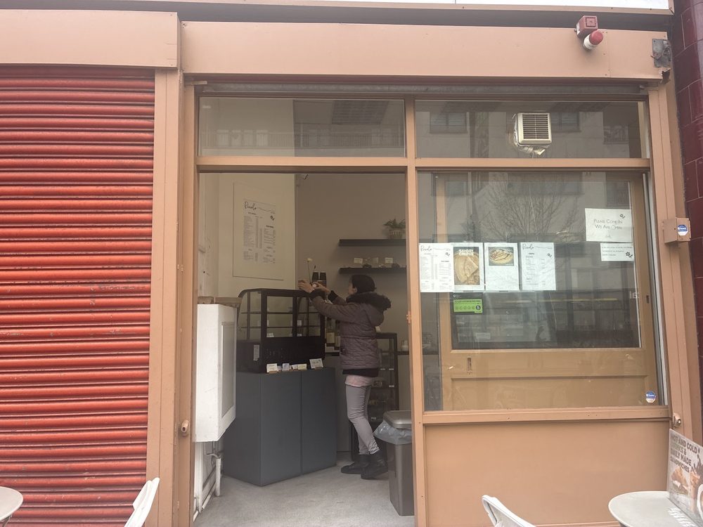 The Piccolo Cafe shopfront on Caledonian Road, open doorway with the counter visible inside